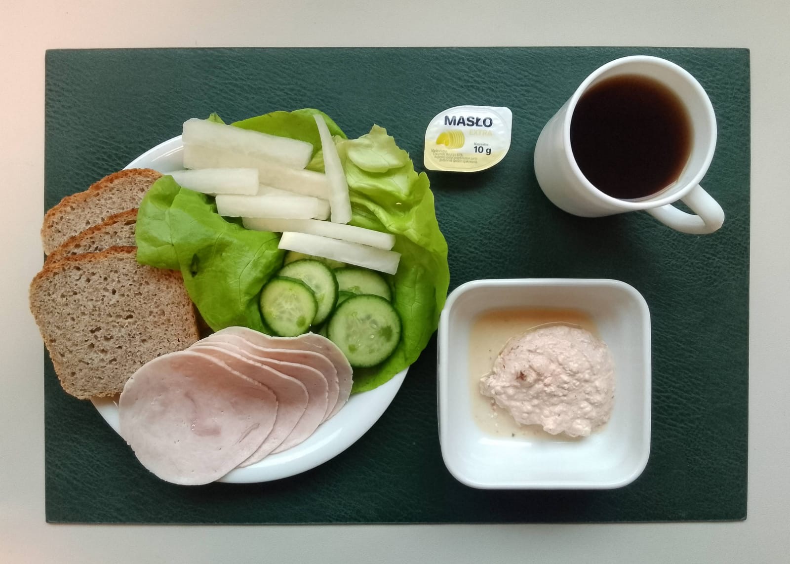 Chleb mieszany razowy żytnio-pszenny 90 g ( GLU PSZ, GLU ŻYT, ) Masło porcjowane 10g (82% tł.) 1 szt ( MLE,) Twarożek pomidorowy + 50 g ( MLE,) Szynkowa dębowa drobiowa kiełbasa grubo rozdrobniona 50 g Plastry ogórka świeżego + 50 g Słupki rzodkwi białej + 50 g Sałata zielona 20 g Herbata czarna ekspresowa z cytryną Cateringowa b/c 250 ml