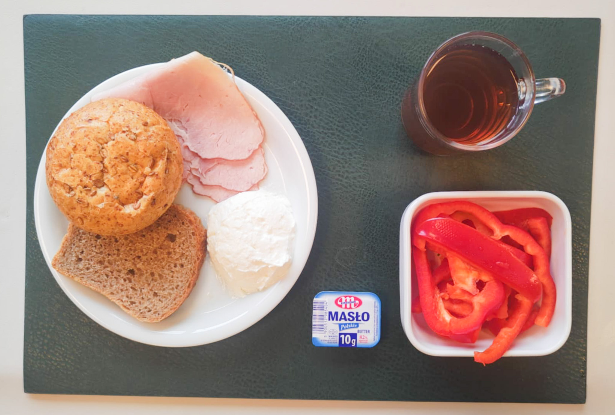 Dieta z ograniczeniem łatwoprzyswajalnych węglowodanów, ubogoenergetyczna, bogatoresztkowa  Bułka pszenna wieloziarnista 50g 1 szt ( GLU PSZ, GLU ŻYT, ) Chleb Graham 30 g ( GLU PSZ,) Masło porcjowane 10g (82% tł.) 1 szt ( MLE,) Szynka od Zduna-wędzonka wieprzowa,szynka wędzona,parzona 50 g Twarożek domowy waniliowy + 50 g ( MLE, może zawierać: GLU PSZ, JAJ, OZI, SOJ, MLE, ORZ, SEZ,) Słupki papryki kolorowej 120 g Herbata czarna ekspresowa z cytryną Cateringowa b/c 250 m