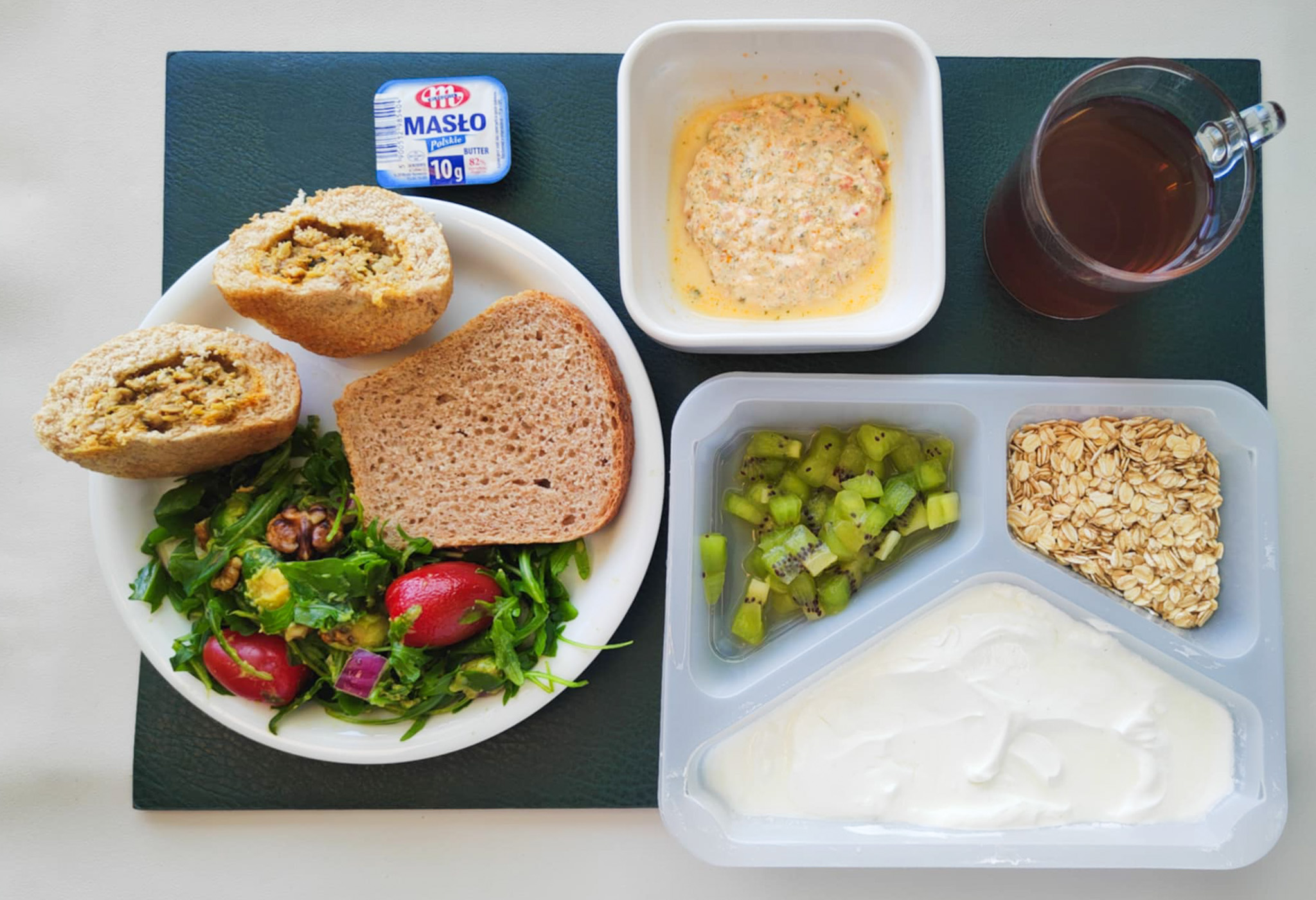 Dieta z ograniczeniem łatwoprzyswajalnych węglowodanów, ubogoenergetyczna, bogatoresztkowa  Bułka orkiszowa z kurczakiem orientalnym + 80 g ( GLU PSZ, JAJ, MLE, SEZ, ) Chleb Graham 30 g ( GLU PSZ,) Masło porcjowane 10g (82% tł.) 1 szt ( MLE,) Pasta twarogowa z zieloną pietruszką + 50 g ( MLE,) Sałatka z rukolą i awokado + 120 g ( SOJ, ORZ,) Herbata ekspresowa owocowa Cateringowa b/c 250 ml  II Śniadanie: Jogurt naturalny z płatkami owsianymi i kiwi + 240 g ( MLE, GLU OW,)