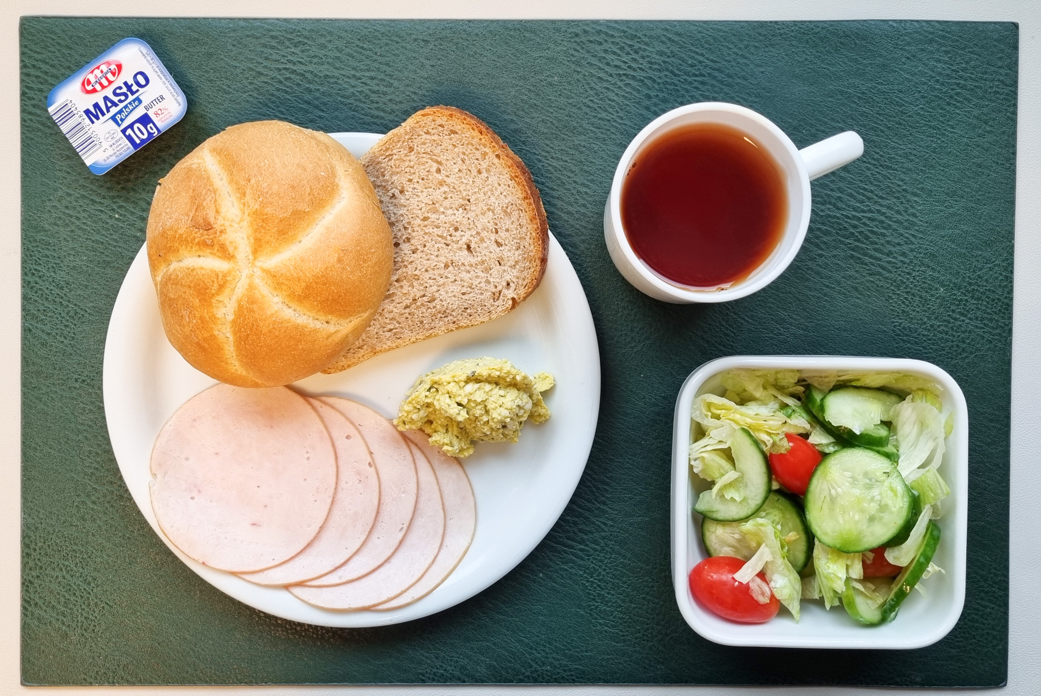   Bułka pszenna kajzerka 50g 1 szt ( GLU PSZ, GLU ŻYT, ) Chleb Graham 30 g ( GLU PSZ,) Masło porcjowane 10g (82% tł.) 1 szt ( MLE,) Szynkowa dębowa drobiowa kiełbasa grubo rozdrobniona 50 g Pasta jajeczna z awokado + 50 g ( JAJ, GOR,) Sałata lodowa z ogórkiem i pomidorkami koktajlowymi z jogurtem + 120 g ( MLE,) Herbata czarna ekspresowa z cytryną Cateringowa b/c 250 ml Cukier 5 g