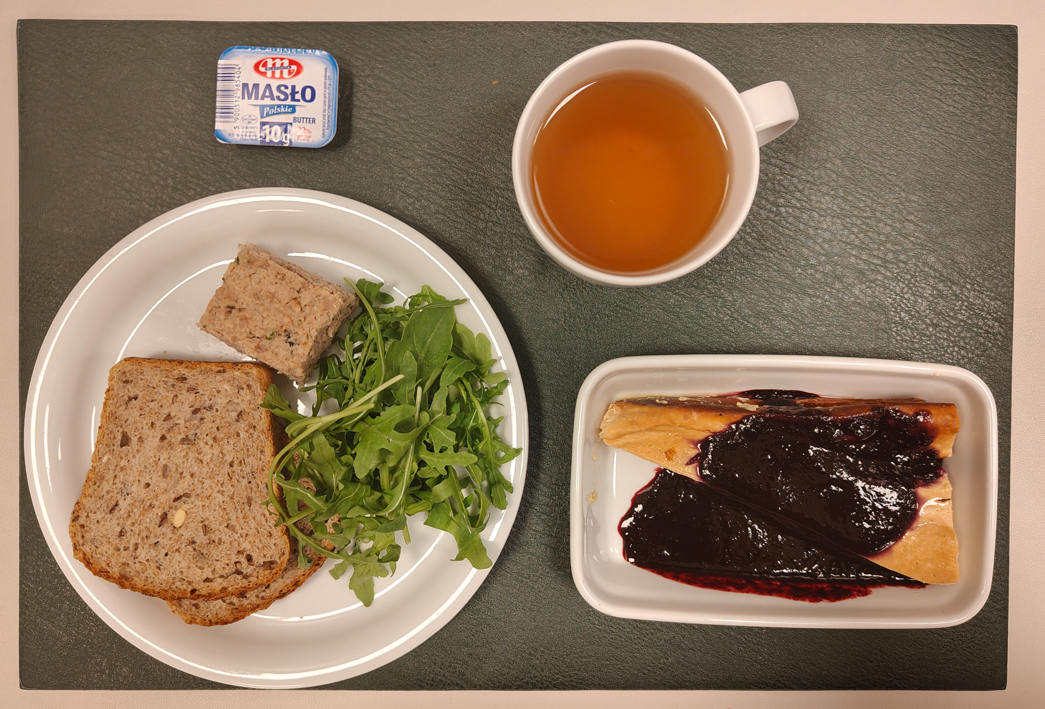 Śniadaniowy sernik z bananami + 150 g ( JAJ, MLE,) Mus jagodowy + 50 g Chleb wieloziarnisty 60 g ( GLU PSZ, SOJ, SEZ, GLU ŻYT, ) Masło porcjowane 10g (82% tł.) 1 szt ( MLE,) Pasztet wieprzowy z żurawiną + 50 g ( GLU PSZ, JAJ, SOJ, MLE, ) Rzodkiewka i ogórek szatkowane z jogurtem i szczypiorkiem + 110 g ( MLE,) Rukola 10 g Herbata czarna ekspresowa z cytryną Cateringowa b/c 250 ml Cukier 5 g