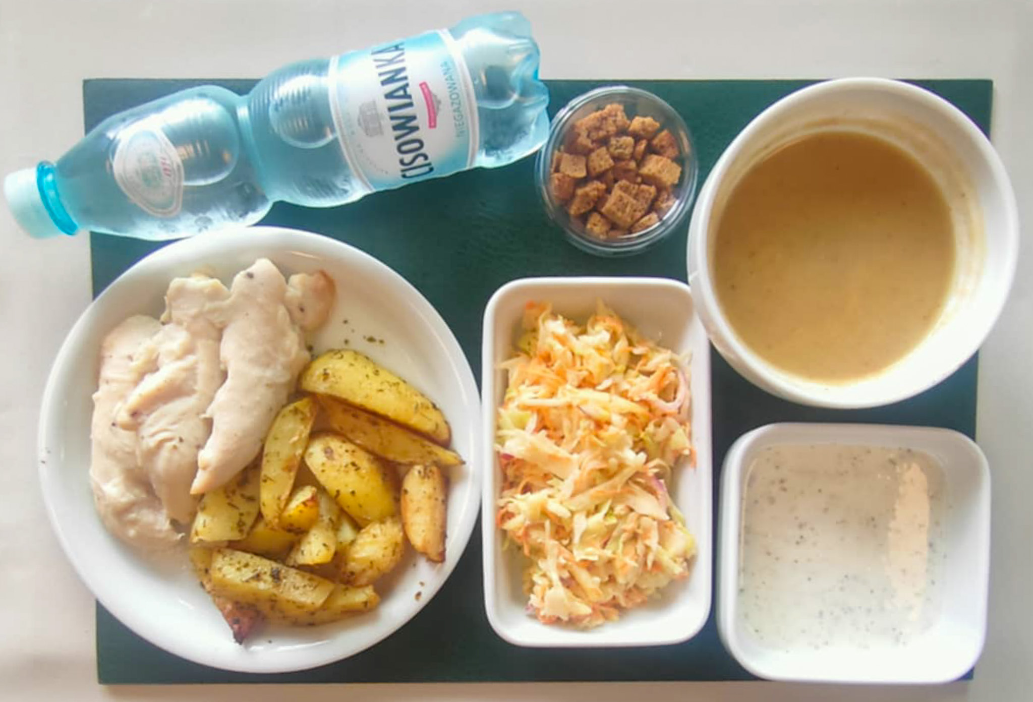 Dieta z ograniczeniem łatwoprzyswajalnych węglowodanów, ubogoenergetyczna, bogatoresztkowa    Zupa krem z białych warzyw + 300 ml ( SOJ, SEL,) Grzanki żytnie + 10 g (GLU ŻYT,) Polędwiczki z kurczaka na parze + 150 g Dip jogurtowo-ziołowy + 100 g ( MLE,) Ziemniaki łódeczki pieczone w ziołach + 150 g Surówka Colesław + 150 g ( JAJ, MLE, GOR, S02,) Woda mineralna n/g 0,5l 1 szt