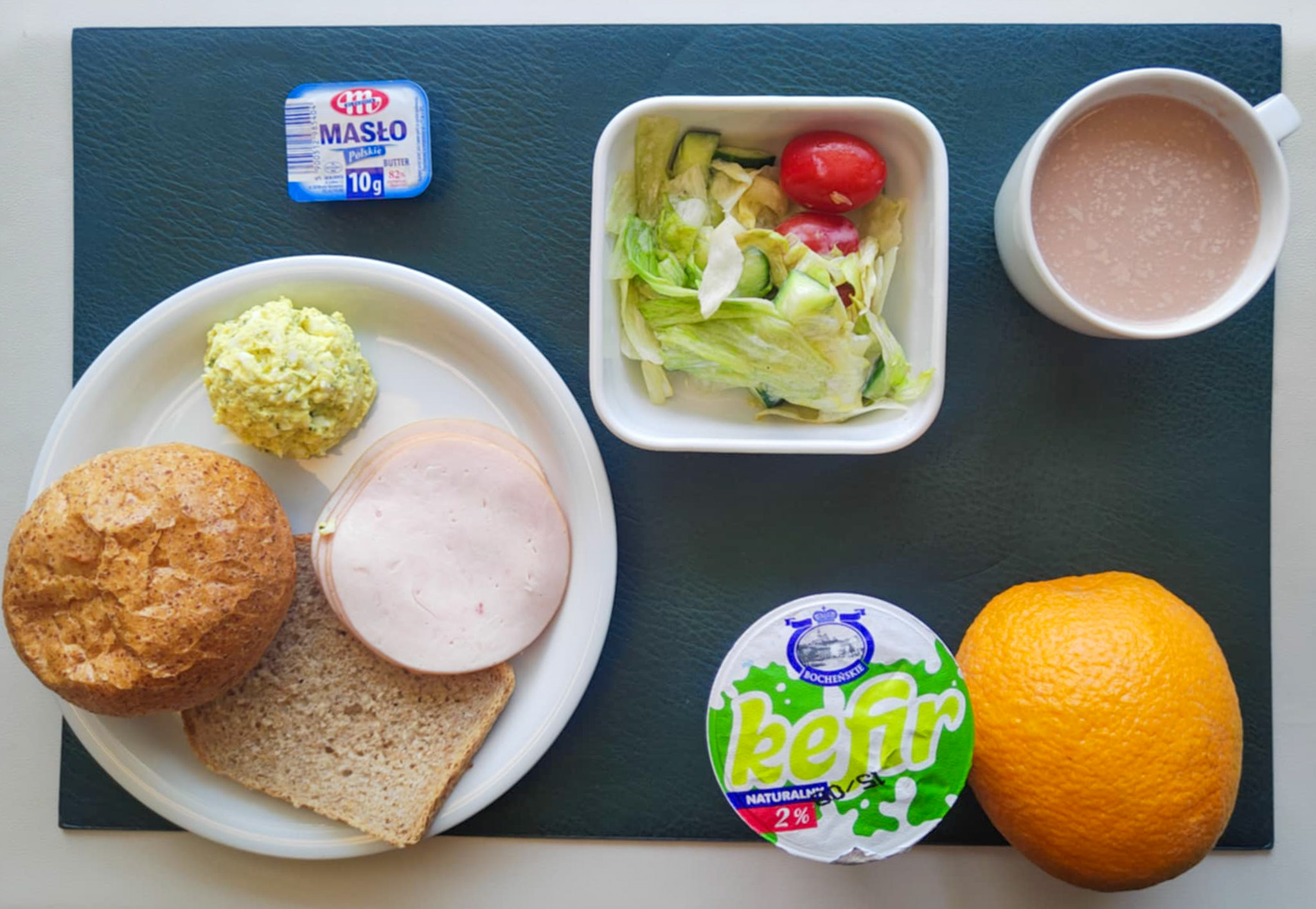 Dieta z ograniczeniem łatwoprzyswajalnych węglowodanów, ubogoenergetyczna, bogatoresztkowa  Bułka graham-pszenna 50g 1 szt ( GLU PSZ,) Chleb Graham 30 g (GLU PSZ,) Masło porcjowane 10g (82% tł.) 1 szt ( MLE,) Szynkowa dębowa drobiowa kiełbasa grubo rozdrobniona 50 g Pasta jajeczna z awokado + 50 g ( JAJ, GOR,) Sałata lodowa z ogórkiem i pomidorkami koktajlowymi + 120 g ( MLE,) Kawa zbożowa z mlekiem b/c 250 ml ( MLE, GLU ŻYT, GLU JĘCZ, )  II Śniadanie: Pomarańcza 200 g Kefir 2 % tł 200g 1 szt (MLE,)