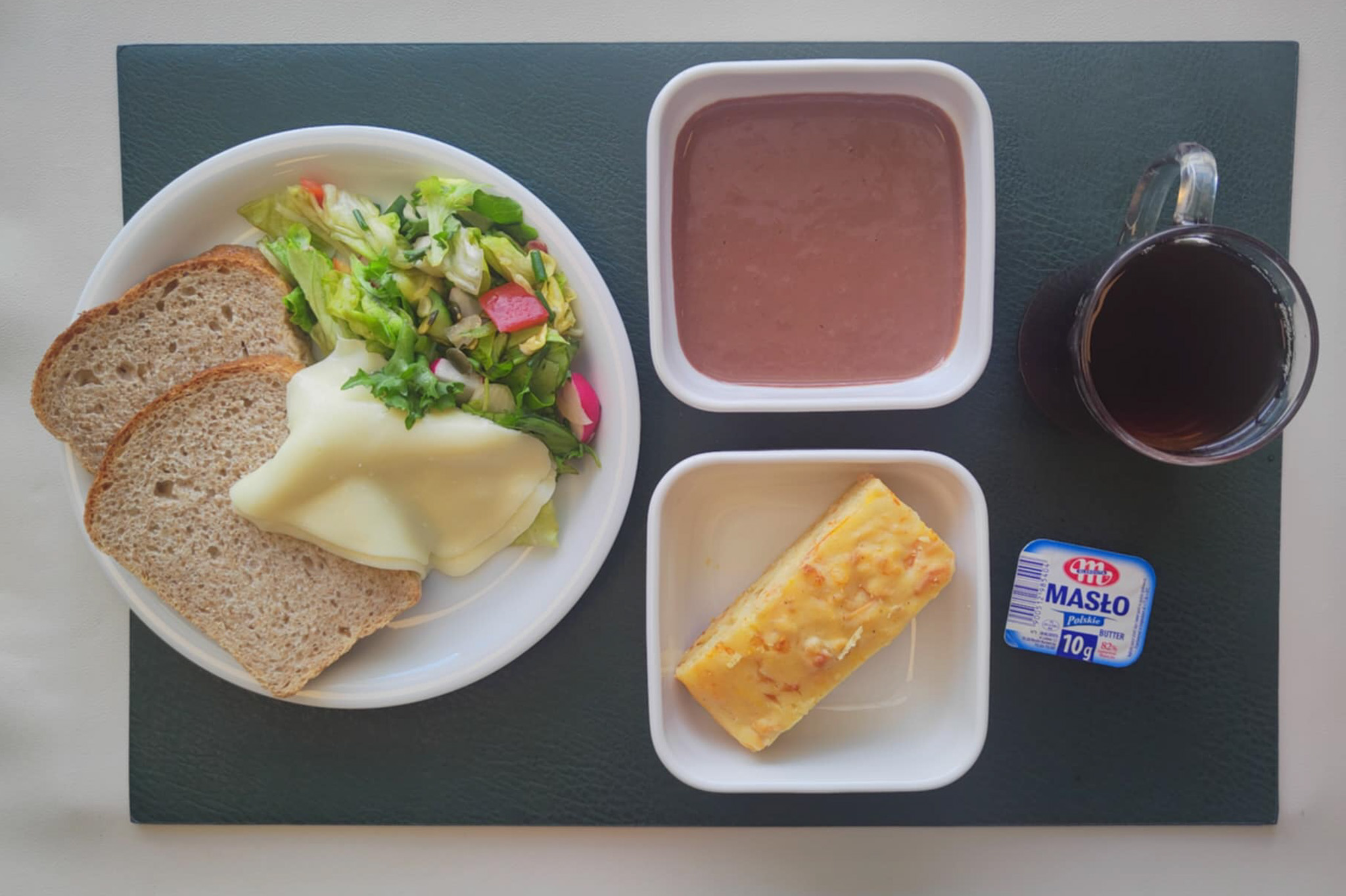 Jogurt bananowo-czekoladowy + 100 g ( MLE,) Wytrawny placek z mozzarellą i warzywami + 75 g ( GLU PSZ, JAJ, MLE, ) Chleb Graham 60 g (GLU PSZ,) Masło porcjowane 10g (82% tł.) 1 szt ( MLE,) Ser mozzarella 40 g (MLE,) Sałatka wiosenna z dressingiem + 120 g ( SOJ,) Herbata czarna ekspresowa z cytryną Cateringowa z/c 250 ml