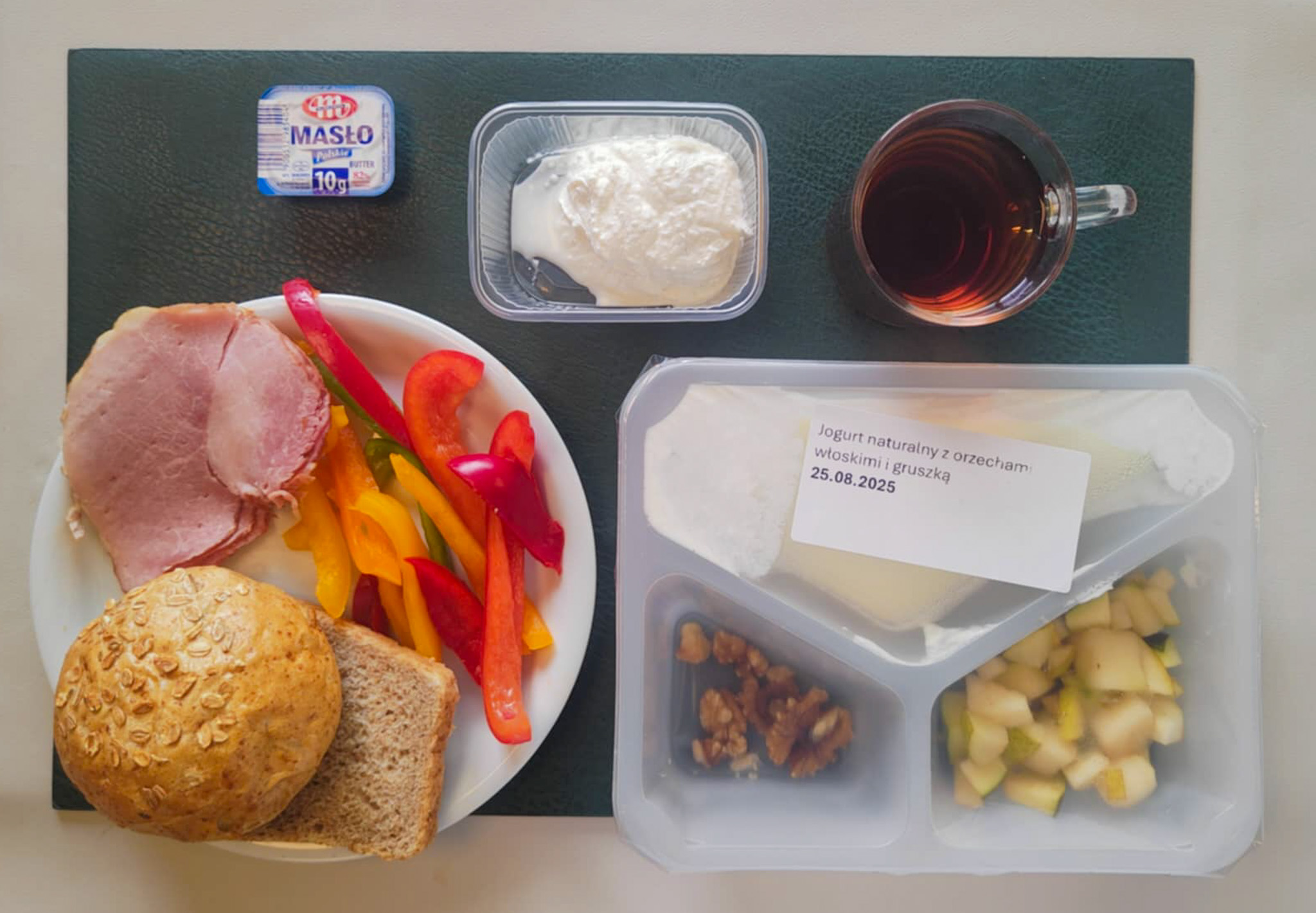 Bułka pszenna wieloziarnista 50g 1 szt ( GLU PSZ, GLU ŻYT,) Chleb Graham 30 g (GLU PSZ,) Masło porcjowane 10g (82% tł.) 1 szt ( MLE,) Szynka od Zduna-wędzonka wieprzowa,szynka wędzona,parzona 50 g Twarożek domowy waniliowy + 50 g ( MLE, może zawierać: GLU PSZ, JAJ, OZI, SOJ, MLE, ORZ, SEZ, ) Słupki papryki kolorowej + 120 g Herbata czarna ekspresowa z cytryną Cateringowa b/c 250 ml