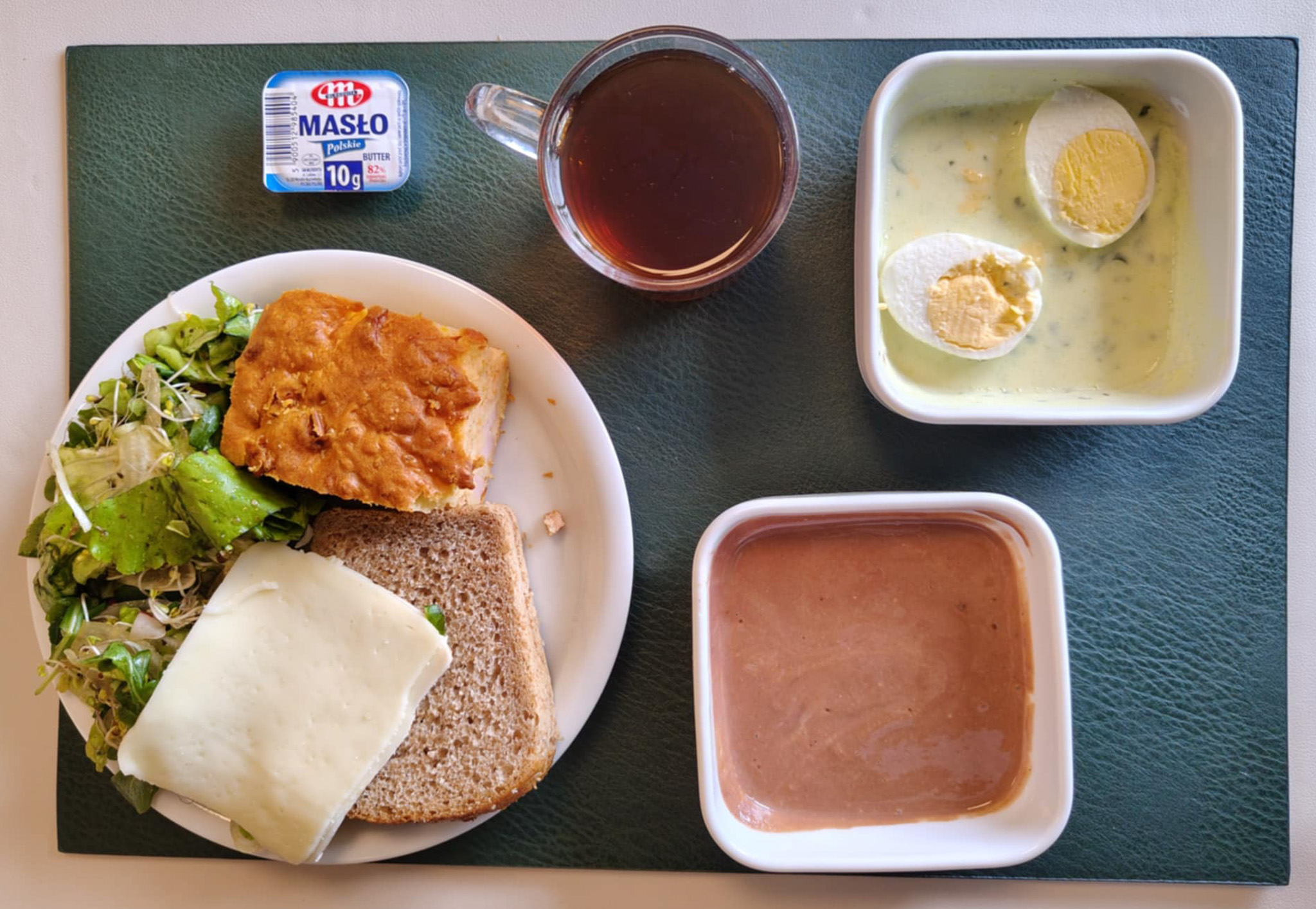 Jogurt bananowo-czekoladowy + 100 g ( MLE,) Wytrawny placek z mozzarellą i warzywami + 75 g ( GLU PSZ, JAJ, MLE, ) Chleb Graham 60 g (GLU PSZ,) Masło porcjowane 10g (82% tł.) 1 szt ( MLE,) Ser mozzarella 40 g (MLE,) Sałatka wiosenna z dressingiem + 120 g ( SOJ,) Herbata czarna ekspresowa z cytryną Cateringowa b/c 250 ml Cukier 5 g