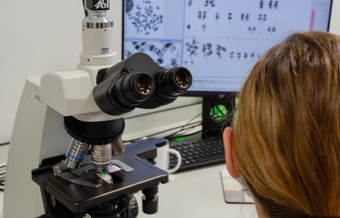 Pracownik Zakładu Diagnostyki Hematologicznej i Genetyki przy sprzęcie - zbliżenie 