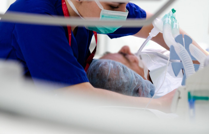 Pielęgniarka pochylająca się nad pacjentem 