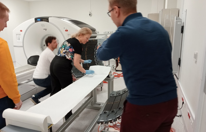 Fot. 2. Przygotowanie łóżka tomografu do pomiarów z pacjentem; od lewej: mgr Wiktor Mryka, dr Grzegorz Korcyl, prof. Ewa Stępień, mgr. Szymon Parzych.